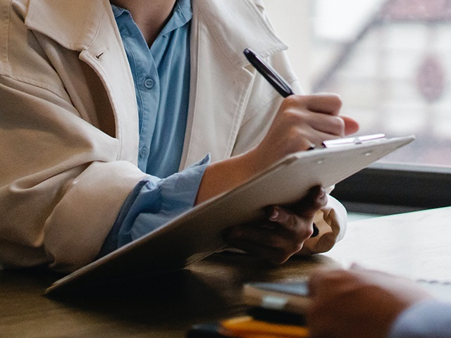 A person writing on a clipboard during an energy usage assessment