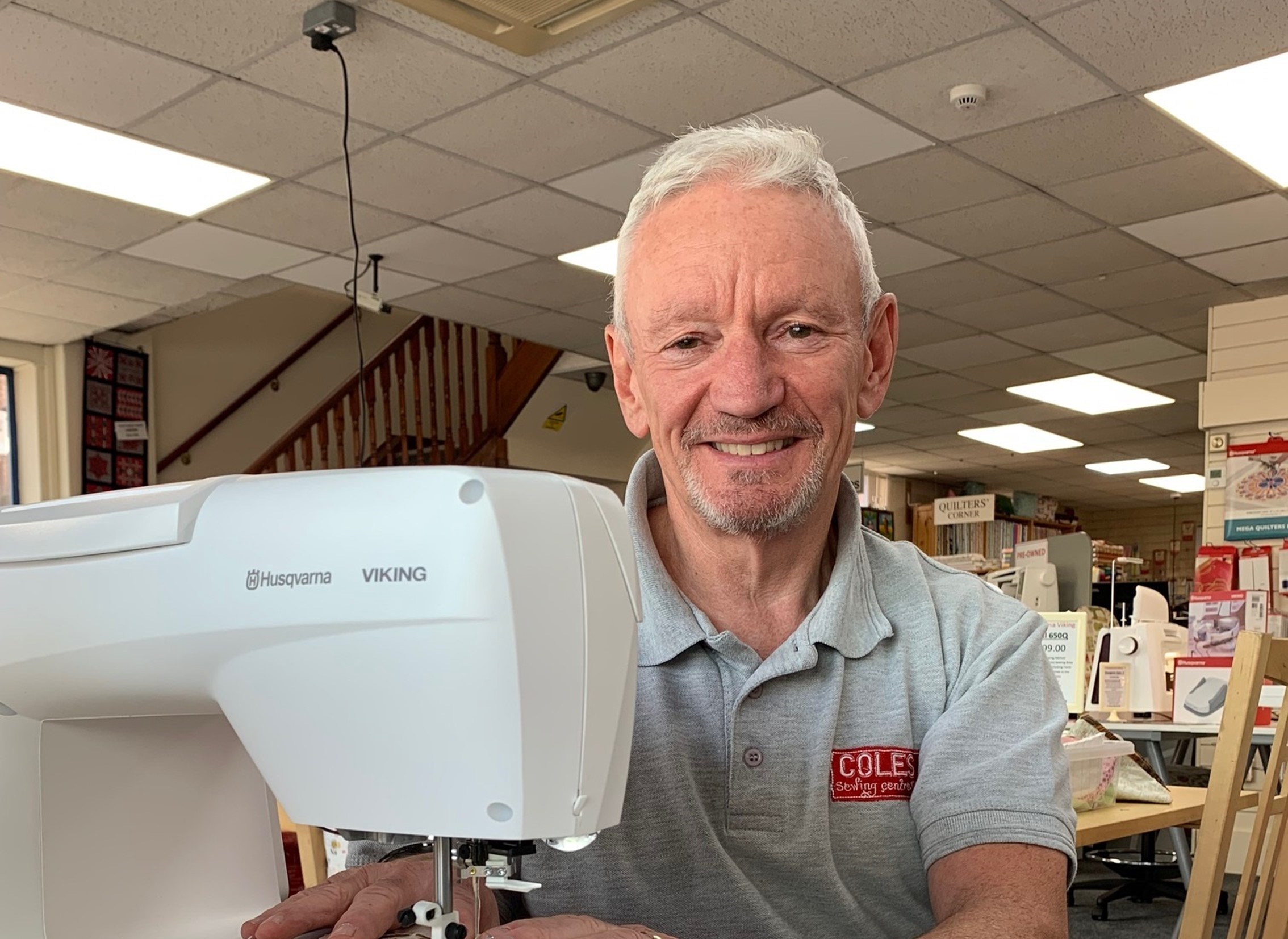 Neil Coles, owner of Coles Sewing Centre, sat behind a sewing machine
